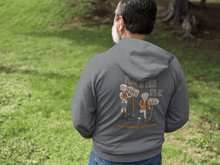 Load image into Gallery viewer, Man standing outside wearing Old People Outdoors hoodie in charcoal | Flat is where it's at | Back view, also available in blue