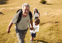 Load image into Gallery viewer, Grandparents walking outside with their grandkid, wearing Old People Outdoors t-shirt in sandstone
