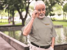 Load image into Gallery viewer, Man standing outside wearing Old People Outdoors tee in sandstone | Also available in granite and ice blue
