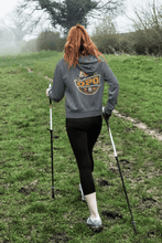 Load image into Gallery viewer, Woman walking outside with hiking poles wearing Old People Outdoors Classic Hoodie in charcoal
